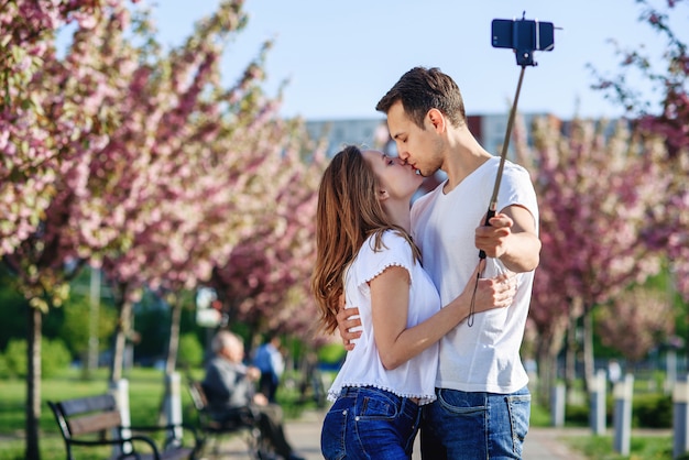 Passie en liefde concept. Man en vrouw kussen in bloeiende tuin op lentedag.