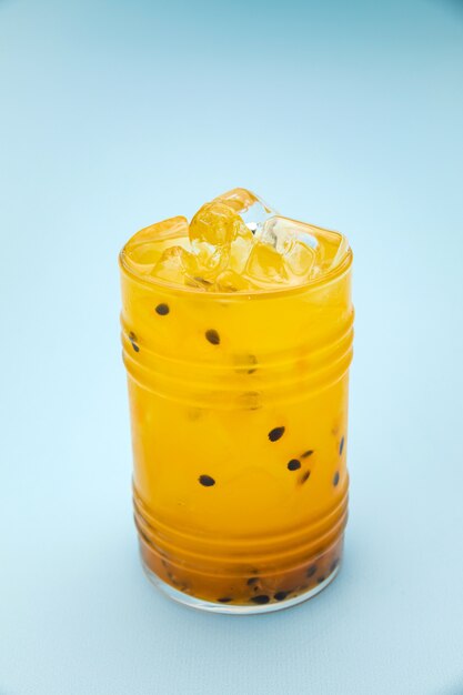 passion fruit lemonade in a bar glass with ice on a blue table