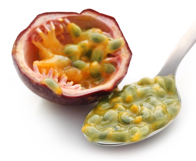 Passion fruit with silver spoon over white background