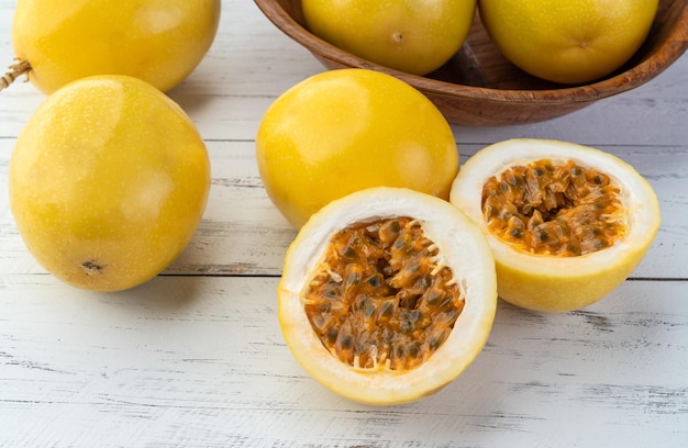 Passion fruits with cut fruit over wooden table