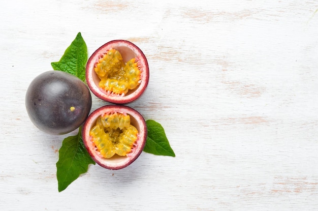 Photo passion fruits with a leaf on a white wooden background tropical fruits top view free space for text