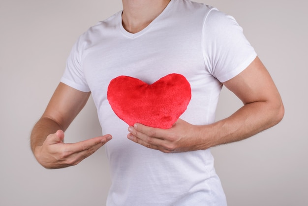 Passion life health healthy support help relief couple concept. Cropped close up photo studio portrait of handsome gentle macho gentleman holding big heart isolated grey background