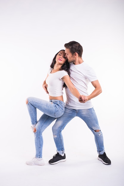 Passionate couple dancing social danse kizomba or bachata or semba or taraxia on white background