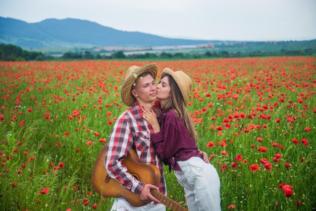 Passionate love summer vacation happy family country music spring nature beauty romance romantic relationship couple in love with guitar man and woman in poppy flower field