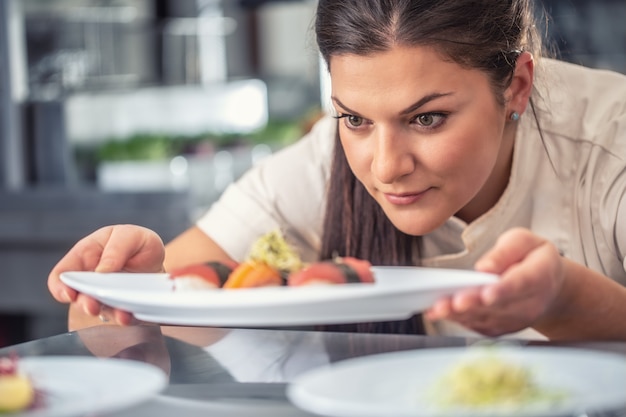 Passionate pro female chef presents her sushi delicacy.