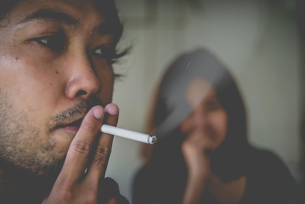 Photo passive smoking conceptasian man is smoking cigarette and woman is covering her faceno tobacco daysmoking is objectionable to societythailand people