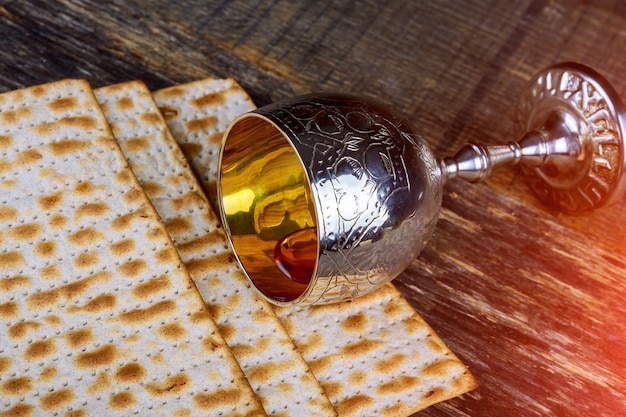 Пасха фон красное вино и маца еврейский праздник хлеб над деревянной доской.
