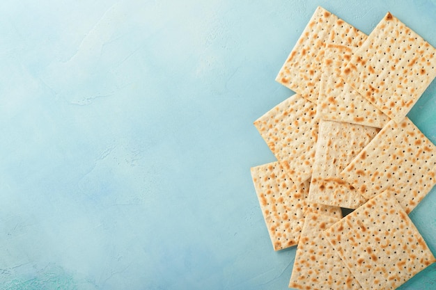 Photo passover celebration concept matzah red kosher walnut and spring beautiful rose flowers traditional ritual jewish bread on light turquoise or blue background passover food pesach jewish holiday