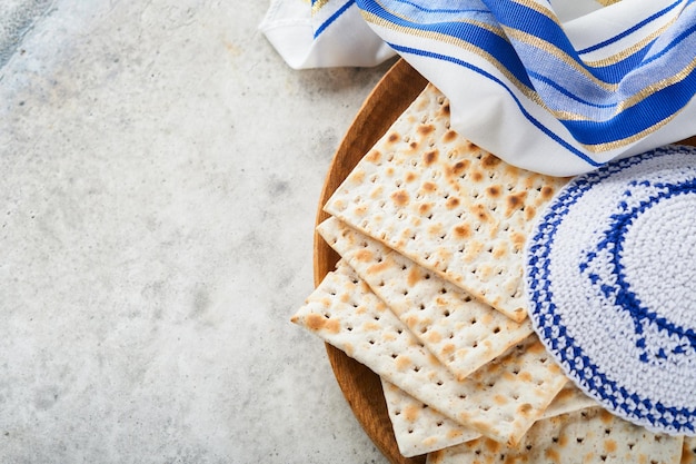 Passover celebration concept Matzah red kosher and walnut Traditional ritual Jewish bread matzah kippah and tallit on old concrete background Passover food Pesach Jewish holiday