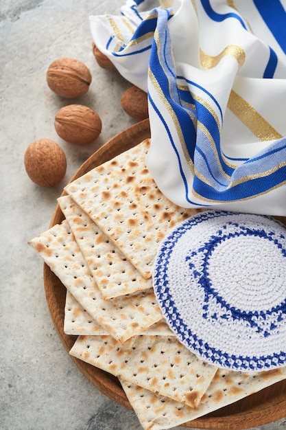 Passover celebration concept Matzah red kosher and walnut Traditional ritual Jewish bread matzah kippah and tallit on old concrete background Passover food Pesach Jewish holiday