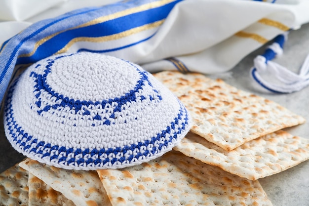 Passover celebration concept Matzah red kosher and walnut Traditional ritual Jewish bread matzah kippah and tallit on old concrete background Passover food Pesach Jewish holiday