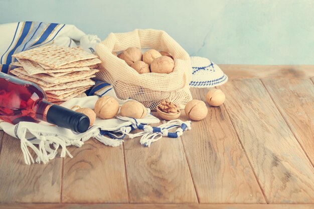 Passover celebration concept Matzah red kosher and walnut Traditional ritual Jewish bread matzah kippah and tallit on old wooden background Passover food Pesach Jewish holiday Toned image