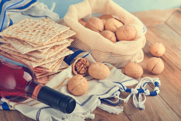 Passover celebration concept Matzah red kosher and walnut Traditional ritual Jewish bread matzah kippah and tallit on old wooden background Passover food Pesach Jewish holiday Toned image