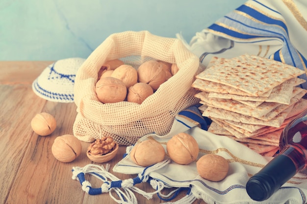 Passover celebration concept Matzah red kosher and walnut Traditional ritual Jewish bread matzah kippah and tallit on old wooden background Passover food Pesach Jewish holiday Toned image