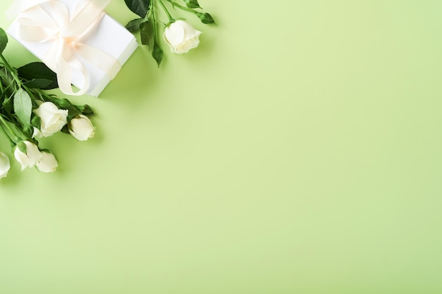 Passover celebration concept Matzah red kosher wine walnut and spring beautiful rose flowers Traditional ritual Jewish bread on light green background Passover food Pesach Jewish holiday