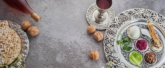 Passover seder plate with traditional food walnuts matza and wine on grunge background