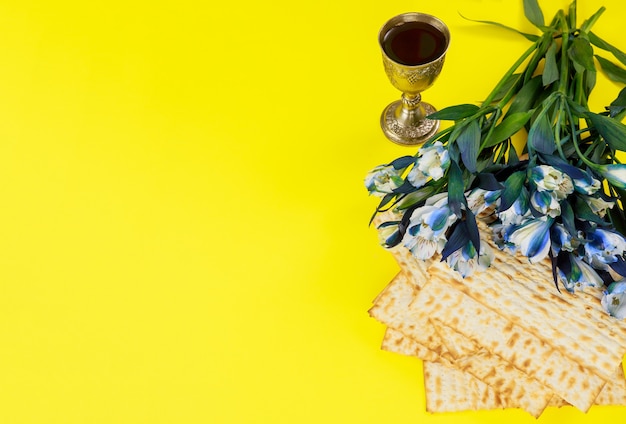 Photo passover symbols matzoh, red wine and flowers. jewish holiday.