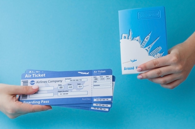 Foto passaporto e biglietto aereo in mano di donna su sfondo blu spazio per la copia del concetto di viaggio