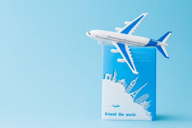 Passport and airplane on a blue background. Travel concept, copy space.