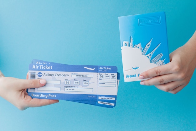 사진 여자 손에 파란색 배경에 여권 및 항공권. 여행 컨셉, 복사 공간