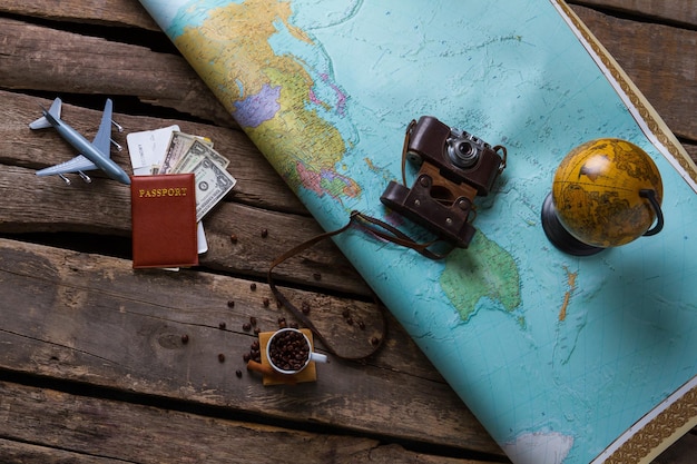 Passport and big map. Globe near vintage camera. Choose any place on map. You can travel freely.