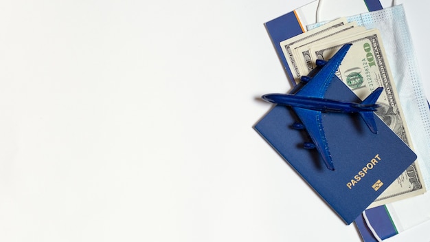 Photo passport and cash in dollars mask and airplane figurine on a white background