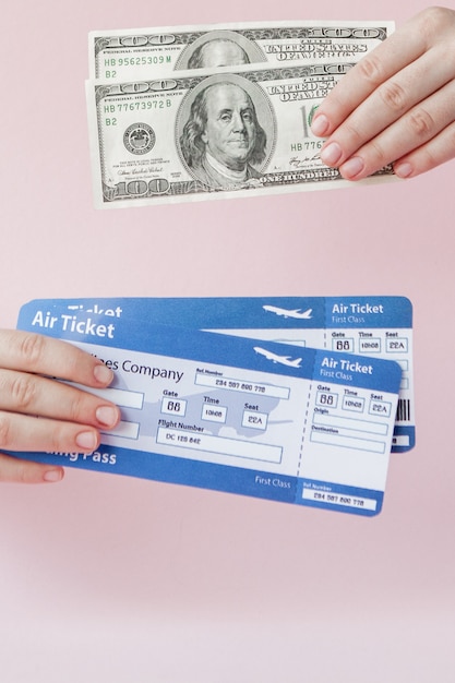写真 パスポート、ドル、女性の航空券はピンクの背景に手します。旅行の概念、コピースペース
