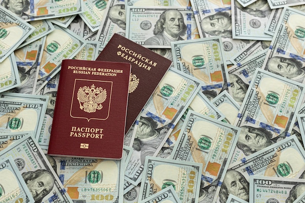 The passport is lying on a pile of hundred dollar bills Documents and money