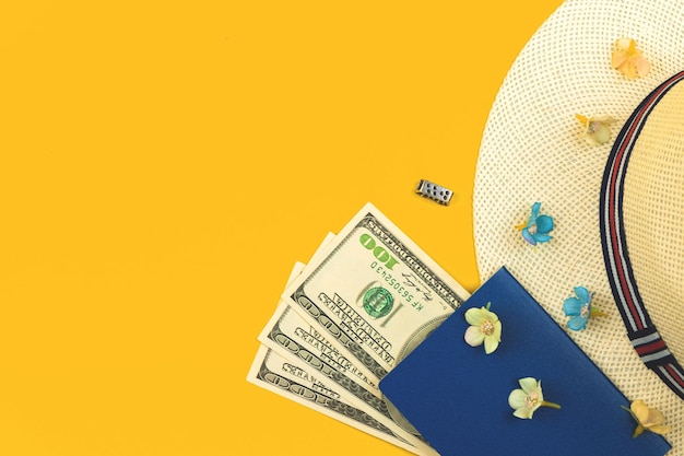 パスポートのお金と麦わら帽子旅行フラットレイ背景コピースペースの夏休みのコンセプトトップビュー写真
