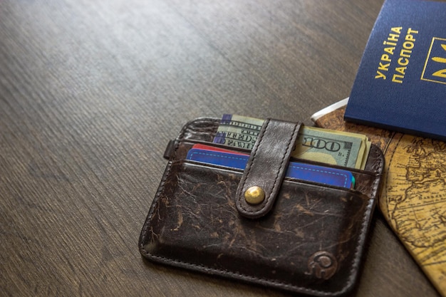 Паспорт и деньги на летнее путешествие на деревянном столе