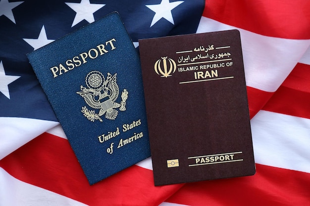 사진 passport of iran republic with us passport on united states of america folded flag close up