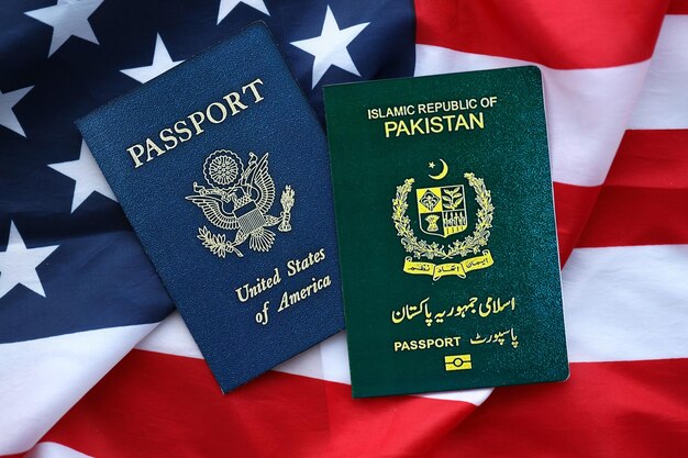 Passport of pakistan with us passport on united states of america folded flag close up