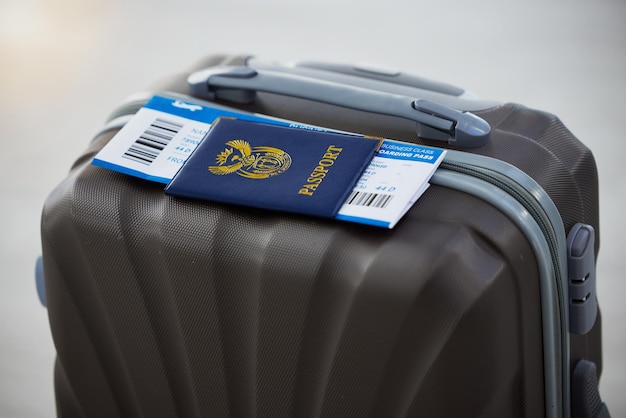 パスポートスーツケースと入国休暇または休暇の空港での旅行の安全のための飛行機のチケット航空会社の飛行機で海外旅行するための荷物書類と飛行機に搭乗するためのビザ