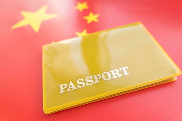 Passport on top of an satin Chinese flagTravelling to China immigration or tourism