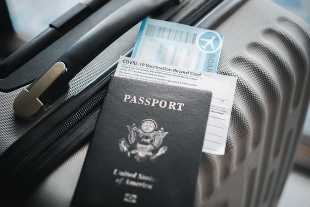 여행 준비를 위한 여권과 여행 가방, 코로나바이러스 예방 접종 카드, 여행용 수하물이 있는 여행용 지도. 전 세계의 코로나19