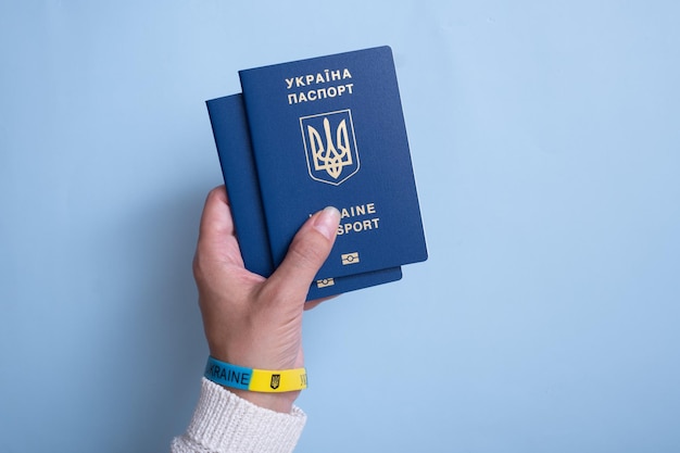 Passports of a citizen of Ukraine and female hand on a blue background closeup Inscription in Ukrainian Ukraine Passport