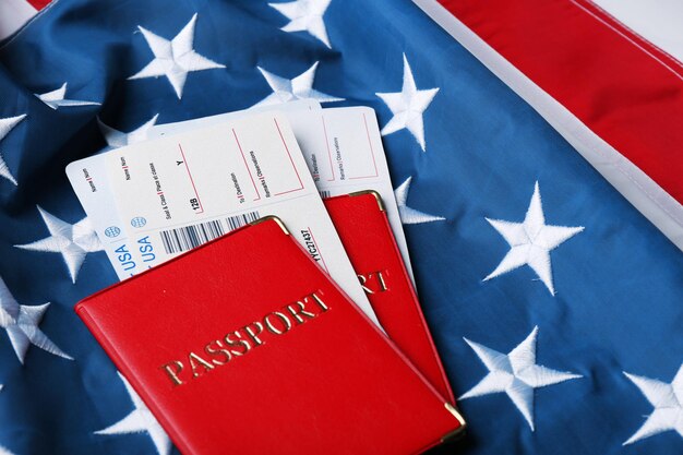写真 アメリカの国旗の背景に横たわっているパスポート チケット