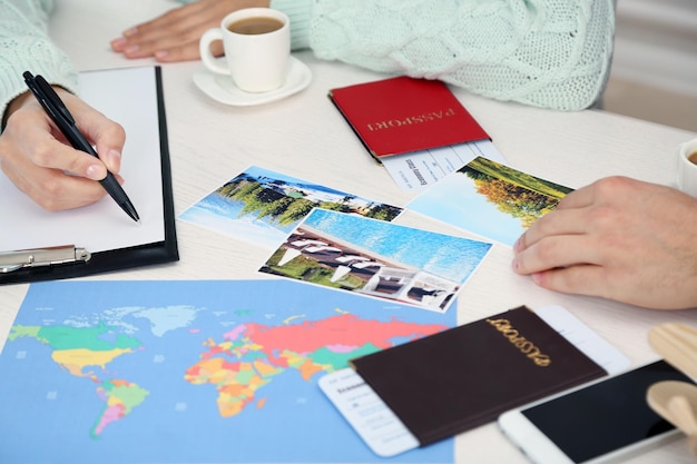 Passports with tickets photos and world map at the table in the office of travel company