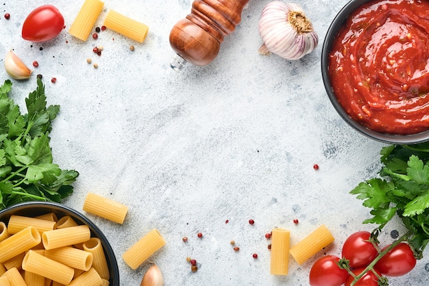 pasta achtergrond pasta rigatoni, tomatenketchupsaus, olijfoliekruiden, peterselie en verse tomaten