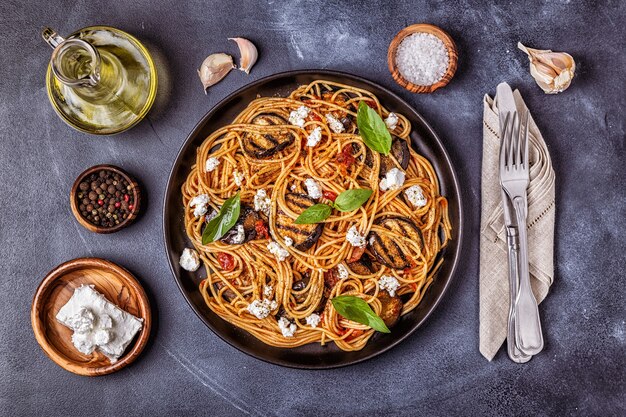 Pasta alla norma. cucina italiana tradizionale con melanzane, pomodoro, formaggio e basilico, vista dall'alto.