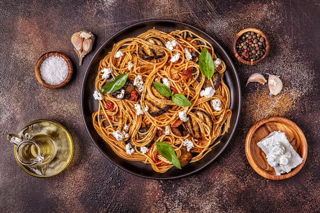 Pasta alla norma - cibo tradizionale italiano con melanzane, pomodoro, formaggio e basilico