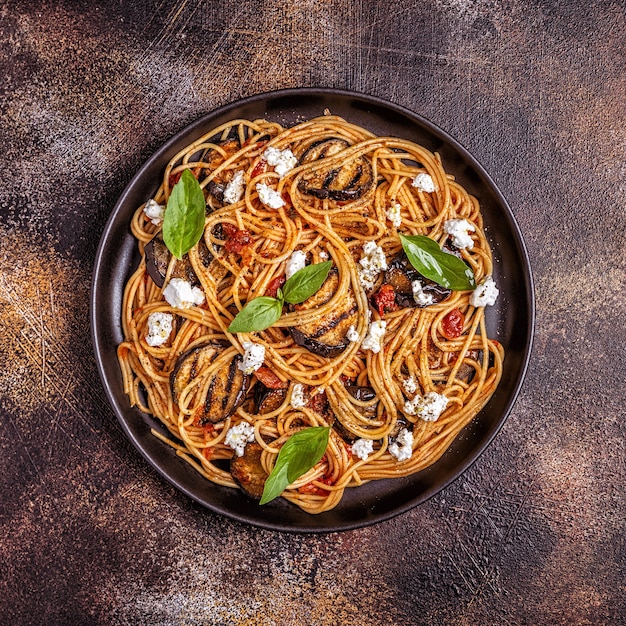 Pasta alla Norma - traditional Italian food with eggplant, tomato, cheese and basil