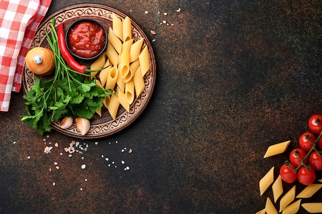 pasta background. pasta rigati, tomato ketchup sauce, olive oil, spices parsley and fresh tomatoes