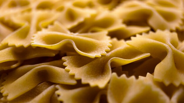 Pasta bows from durum wheat Food background close up Uncooked Italian pasta