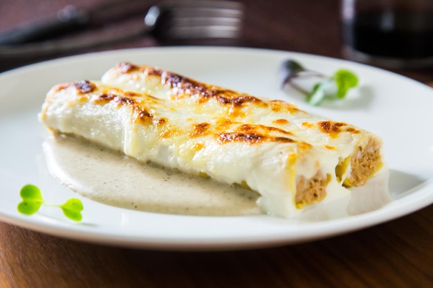 Foto cannelloni di pasta ripieni di carne, verdure e spinaci gratinati al forno. natale tradizionale