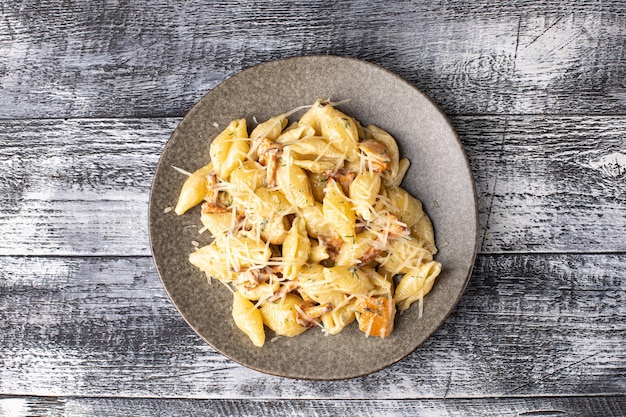 Pasta carbonara belenese with chicken on a white wooden background