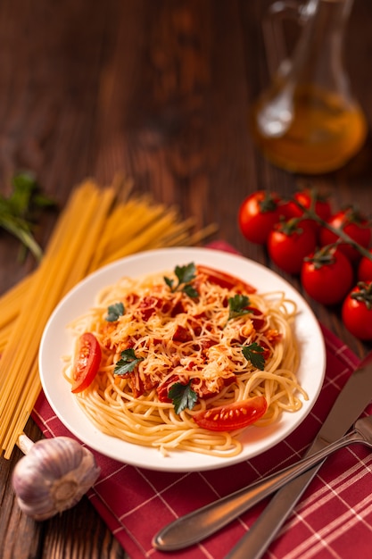 Pasta carbonara met tomatensaus en gehakt, geraspte Parmezaanse kaas en verse peterselie