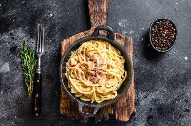 Pasta Carbonara with bacon and parmesan in a pan.