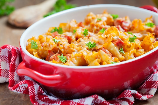 Pasta casserole with bacon, ham, cheese and tomato sauce