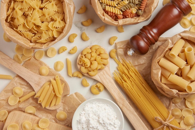 Pasta concept sommige soorten pasta worden georganiseerd op houten lepels en in papieren zakken